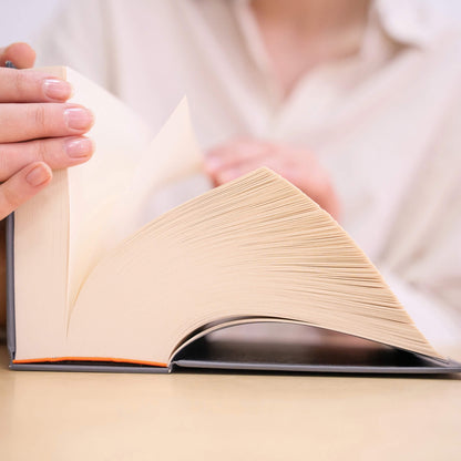Person flipping through the basenotes 0512 Notebook, revealing hundreds of creamy, acid-free pages bound by hand for lasting durability.